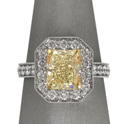 Radiant Fancy Yellow Diamond ring with halo in two tone 18 karat gold