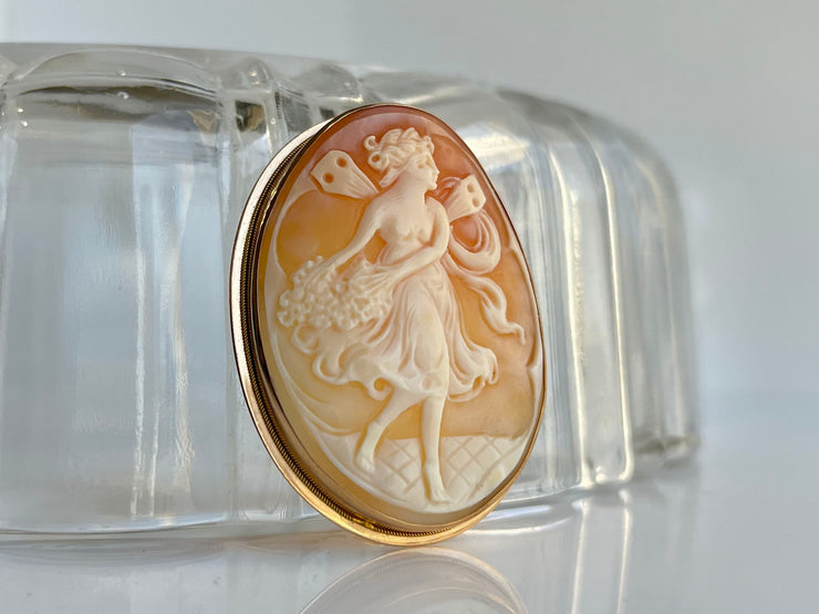 Photographed from a gentle angle, this shot highlights the raised profile of the cameo and the contour of the gold frame. The natural curvature and three-dimensional quality of the carving are beautifully emphasized, giving a sense of depth and lifelike presence.