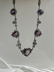 Exquisite turn-of-the-century necklace featuring an 18ct rose-cut amethyst heart, framed by intricate gold detailing, crafted in 18K yellow gold.