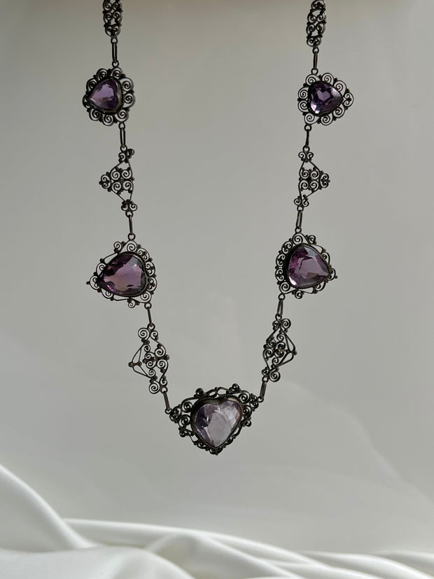 Exquisite turn-of-the-century necklace featuring an 18ct rose-cut amethyst heart, framed by intricate gold detailing, crafted in 18K yellow gold.