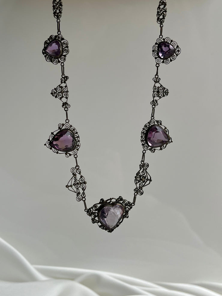 Exquisite turn-of-the-century necklace featuring an 18ct rose-cut amethyst heart, framed by intricate gold detailing, crafted in 18K yellow gold.