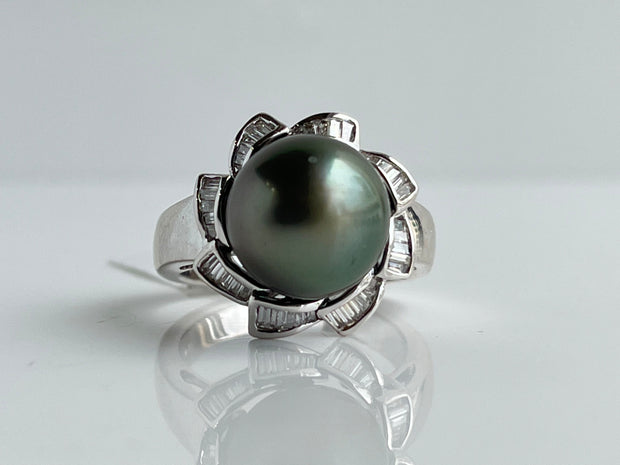 A luminous black pearl and striking diamonds create a ring of rare sophistication.