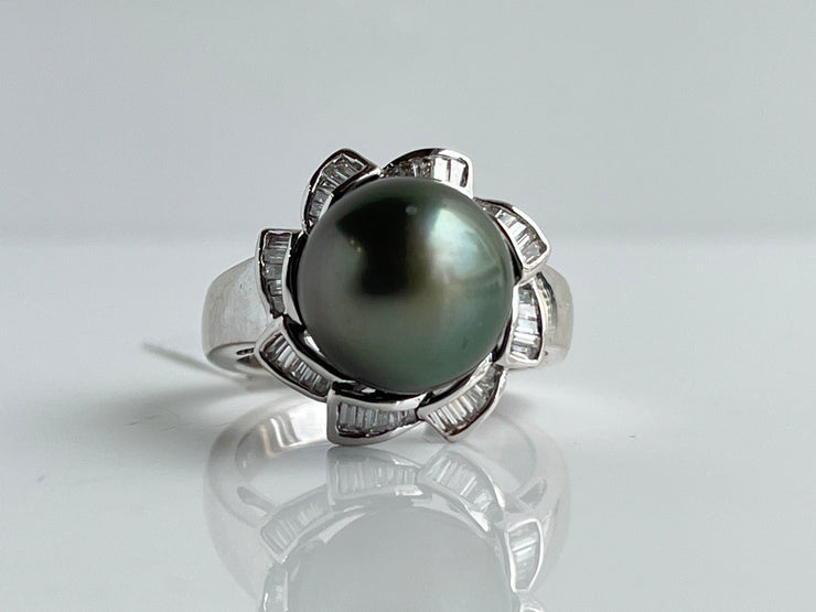 A luminous black pearl and striking diamonds create a ring of rare sophistication.