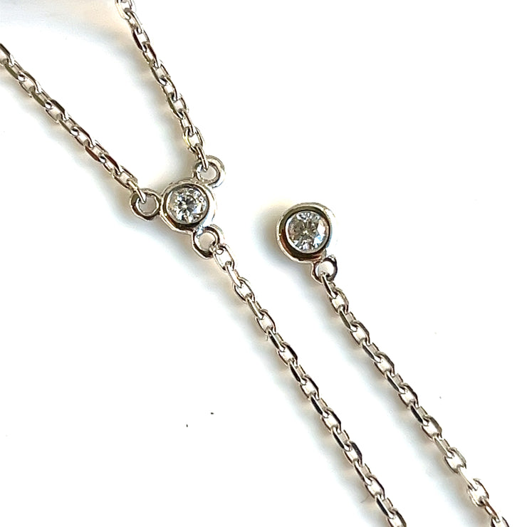 A close up detail of the round brilliant bezel-set lariat necklace.