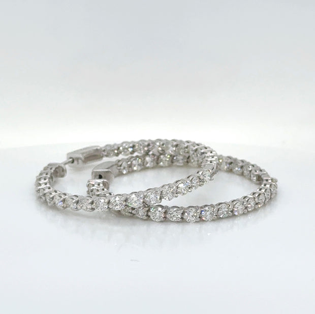 Elegant diamond hoop earrings with a total carat weight of 4.5 CTW, showcasing an inside-out design while laying down.