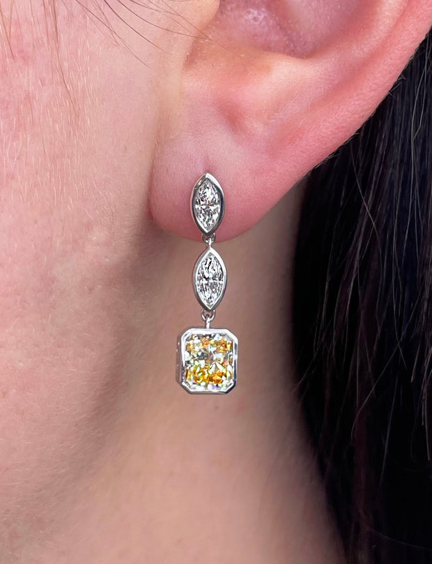 Fancy yellow diamond drop earrings shown on model. 