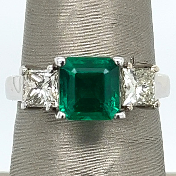 Emerald at the center, diamonds on each side—color, sparkle, and symmetry in harmony.
