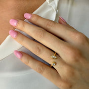 Model wearing a modern two diamond yellow gold bypass ring