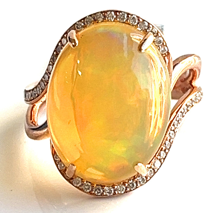 A 6.30 ct opal shimmering with shifting hues, surrounded by delicate diamonds in 14K rose gold.
