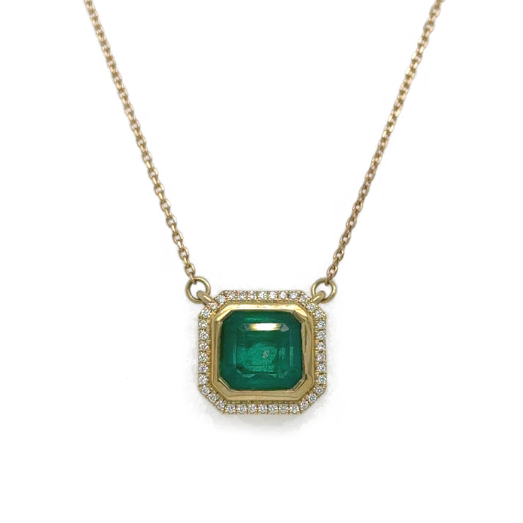 Close-up of the Asscher Cut Green Emerald Necklace, highlighting the vibrant 1.80 ct emerald surrounded by radiant diamonds in a refined 18K yellow gold setting.