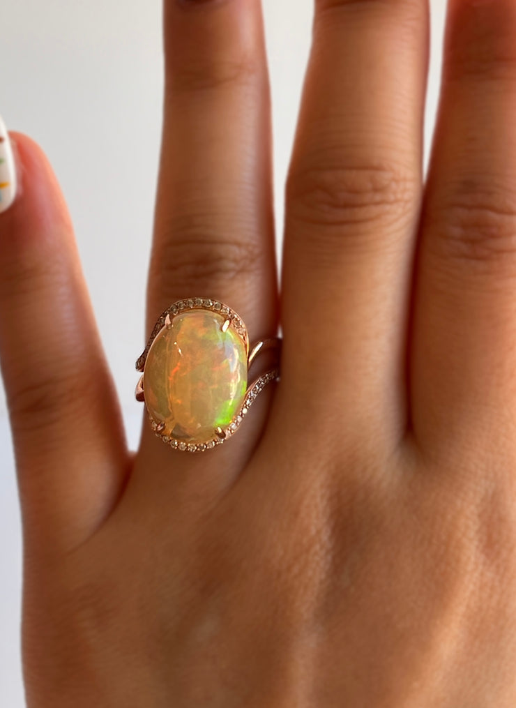 Shown on hand this opal ring catches light from every angle, with diamonds enhancing its natural brilliance.

