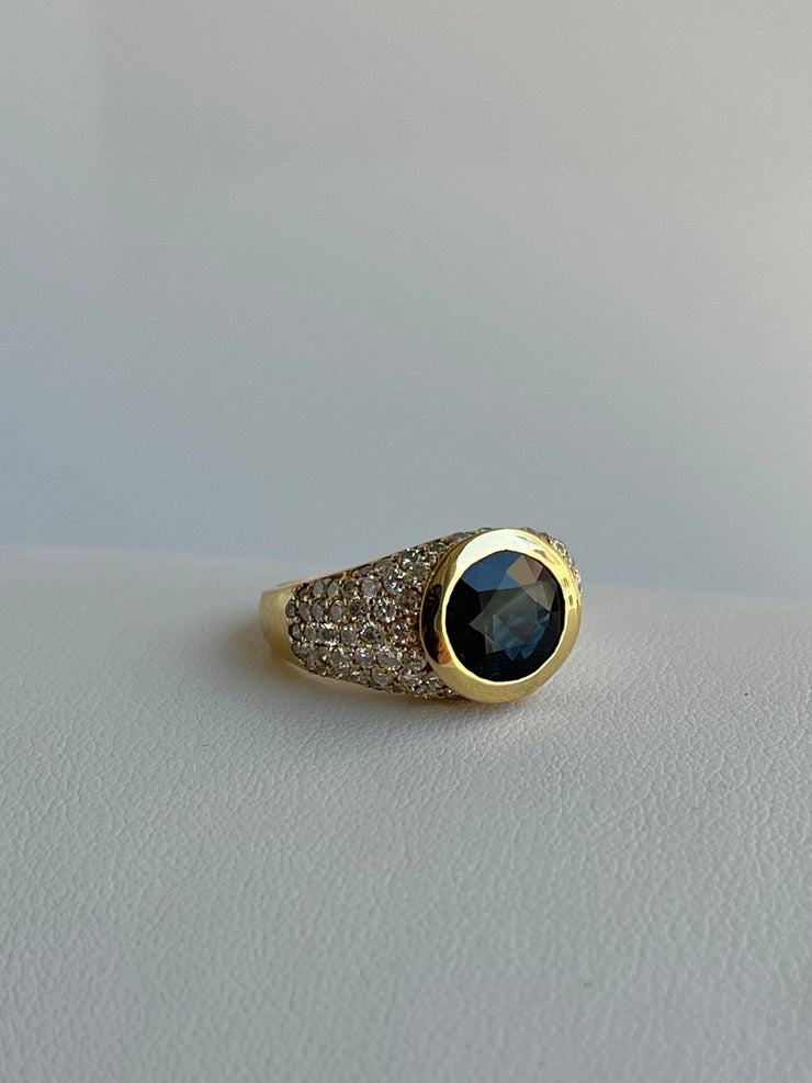 A profile angle of the ring reveals the elegant rise of the setting, allowing light to pass through the gemstones and enhancing their sparkle. The craftsmanship of the goldwork on full display.