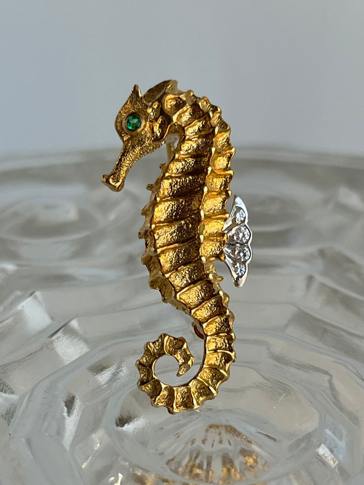 A direct, centered shot of the brooch reveals Tiffany & Co.’s masterful craftsmanship—a beautifully sculpted seahorse rendered in rich 18K yellow gold. Its graceful curve and textured detailing bring the ocean-inspired design to life, while the emerald eye and diamond fin add a touch of understated luxury.