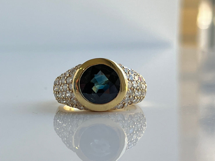 A close-up of the center stone and side diamonds, capturing the fine craftsmanship and fire of the 1.35 carats of natural diamonds. The sapphire’s deep, velvety blue glows with brilliance, highlighting its exceptional quality and allure.