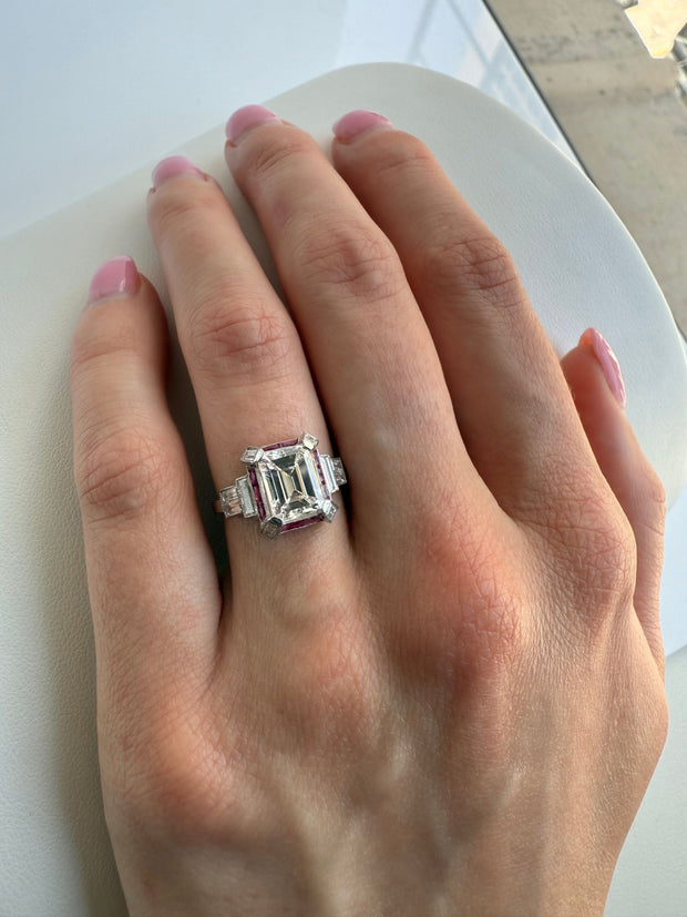 Shown on hand highlighting its beautiful emerald cut center stone.