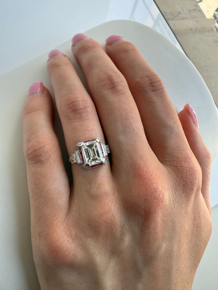Shown on hand highlighting its beautiful emerald cut center stone.