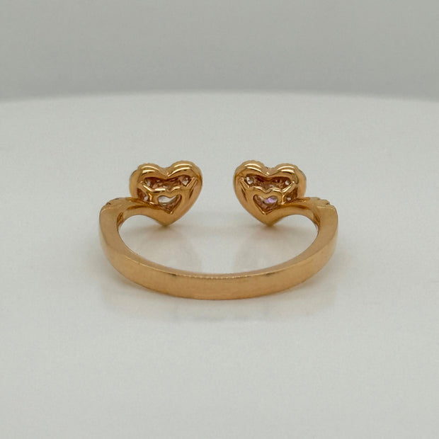 Rose gold open ring with two diamond hearts on a white background