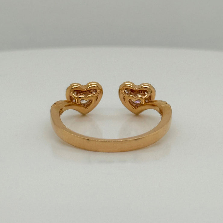 Rose gold open ring with two diamond hearts on a white background