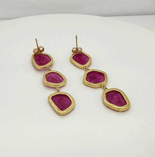 Back view of pair of no-heat ruby slice earrings with 18k yellow gold setting on white background