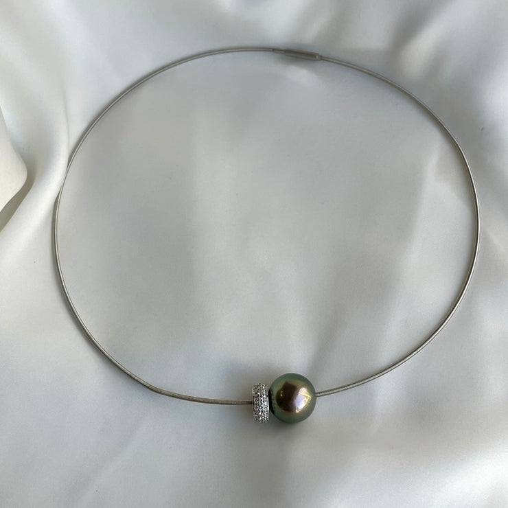 Detailed close-up reveals the rich, exotic hues of the Tahitian black pearl contrasted beautifully against the brilliant natural diamonds and sleek platinum setting.