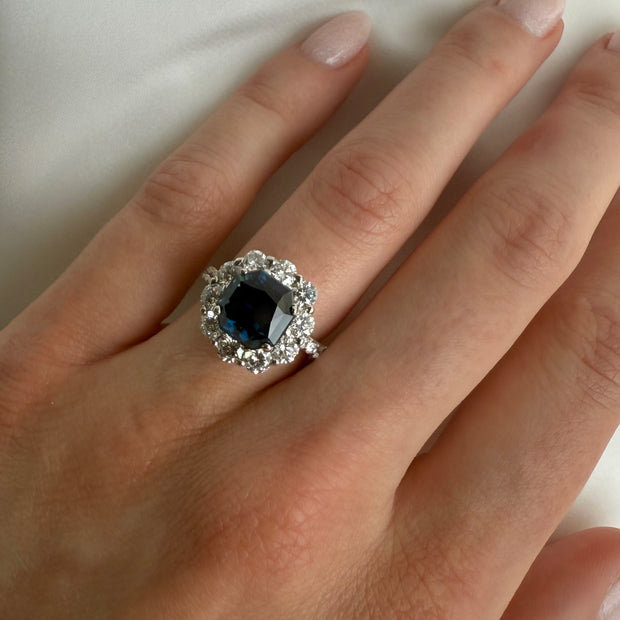 Elegant 3.7 carat sapphire engagement ring with diamond detailing, shown on a model's hand