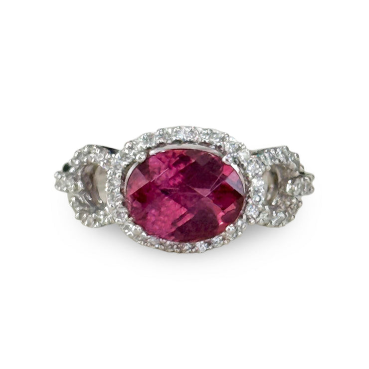 Vibrant oval pink tourmaline gemstone ring in an east west setting accented by diamonds.