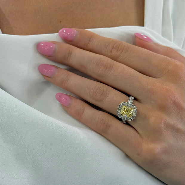 Model wearing a 2.04 CT radiant cut Fancy Yellow diamond ring with diamond halo in 18K two-tone gold.