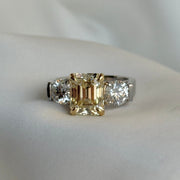 Fancy Yellow emerald diamond ring in platinum with yellow gold prongs and round diamond accents