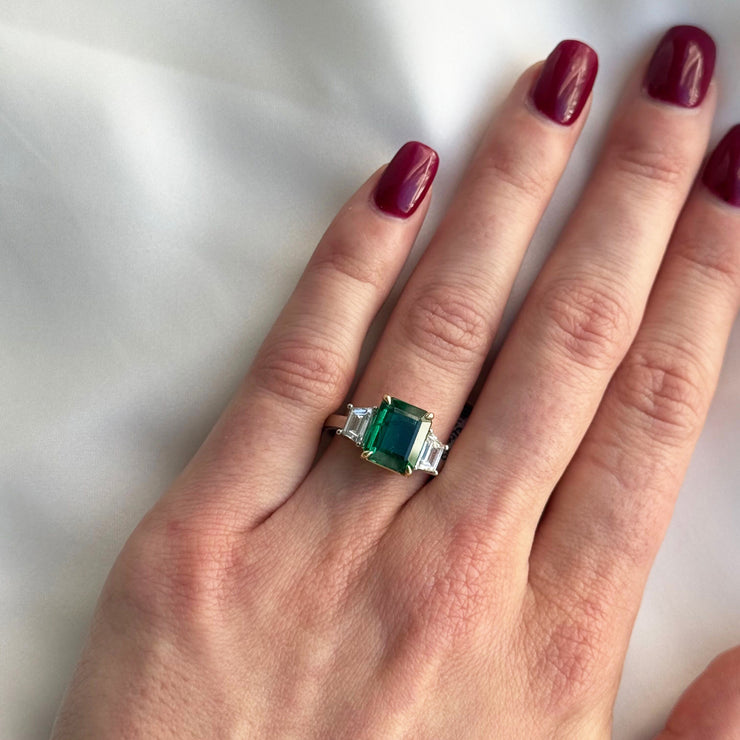 Stunning three stone ring shown on models hand.
