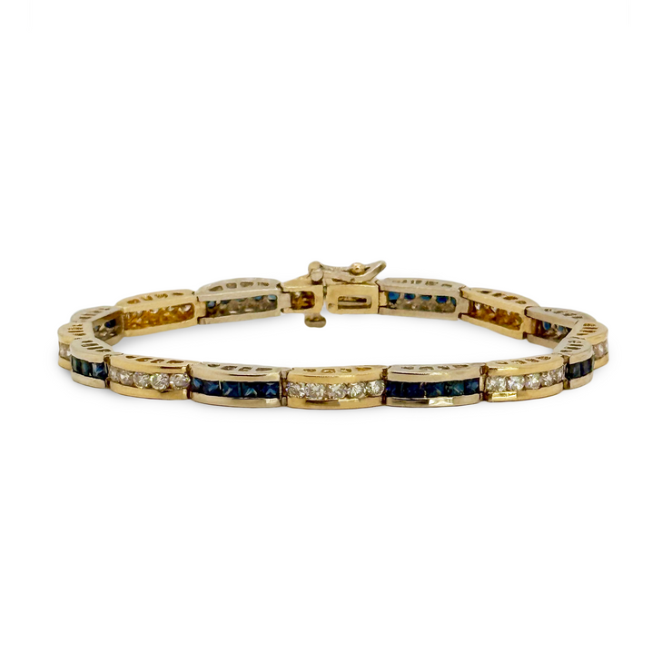 Gold bracelet with blue sapphires and diamonds on a white background