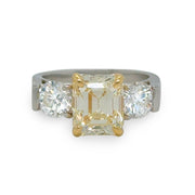2.80ct Fancy Yellow emerald-cut diamond ring with round side diamonds in platinum and yellow gold