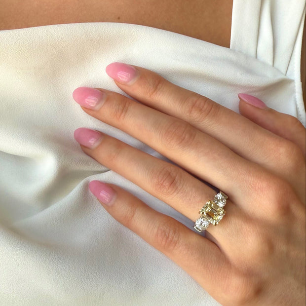 Model wearing 2.80ct Fancy Yellow emerald-cut diamond ring with round side diamonds.