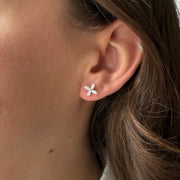 Close-up of an ear wearing a diamond floral earring 