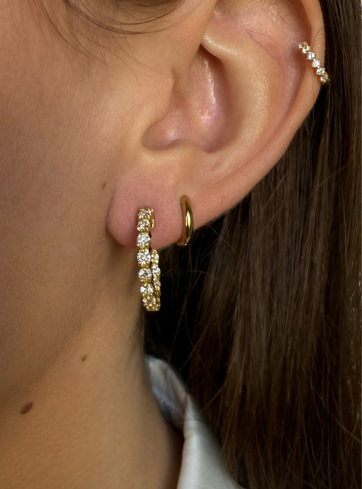 Radiant diamond hoop earrings featuring a total carat weight of 1.7 CTW, designed in 18K yellow gold shown on a model.