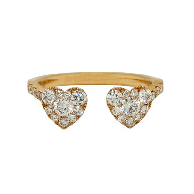 Rose gold bypass ring with heart-shaped diamond designs on a white background