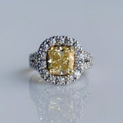 3.01 carat Fancy Yellow Diamond ring with halo of round brilliant diamonds, set in two-tone 18K yellow and white gold