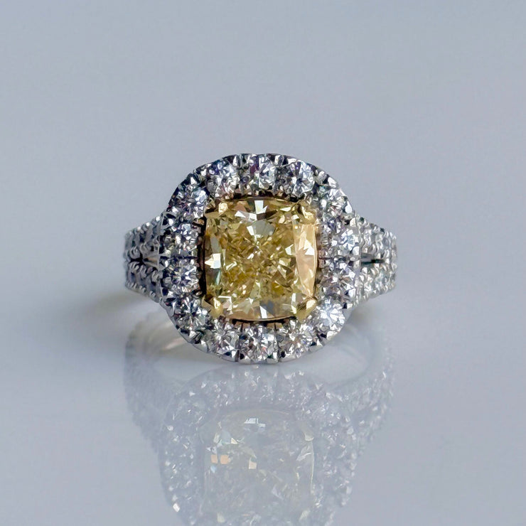3.01 carat Fancy Yellow Diamond ring with halo of round brilliant diamonds, set in two-tone 18K yellow and white gold