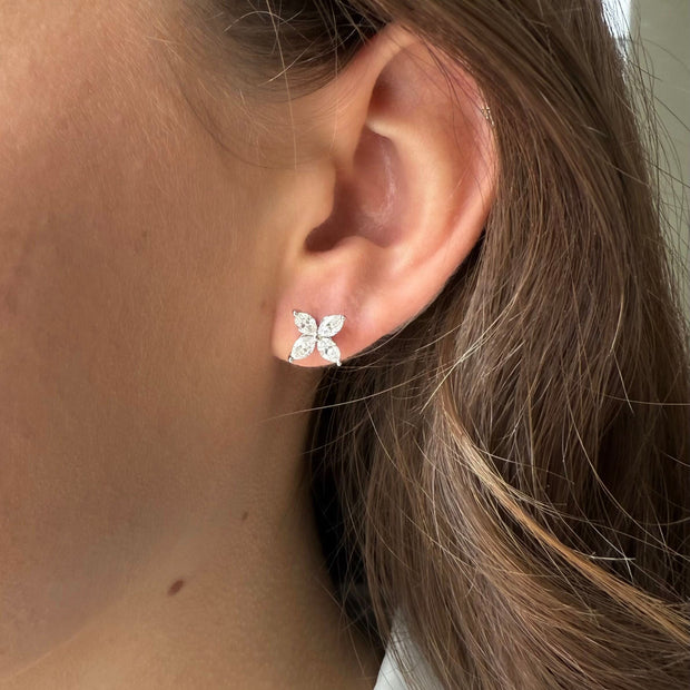 Close-up of an ear wearing a flower marquise diamond stud earrings