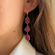Elegant three-stone natural ruby slice drop earrings on a model