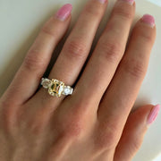 Elegant yellow and white diamond ring shown on hand in natural lighting