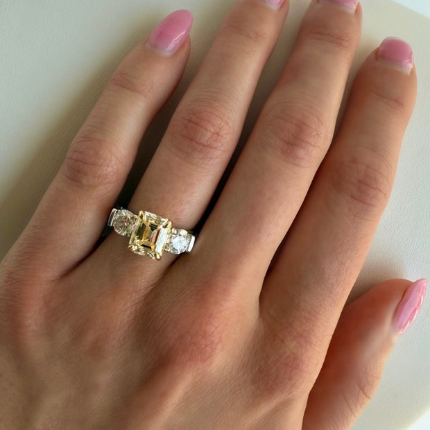Elegant yellow and white diamond ring shown on hand in natural lighting