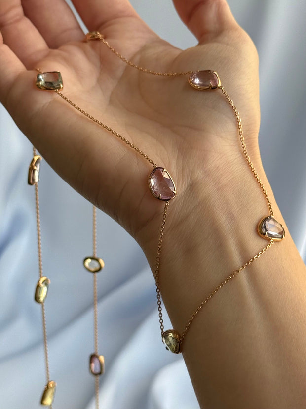 Multi-colored natural sapphire slice by the yard necklace gracefully displayed on a model's hand.