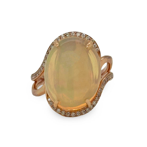 Ring with a large opalgemstone and rose gold band on a white background