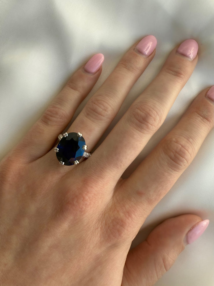 11.26 carat oval-cut sapphire with vivid deep blue color shown on model.