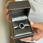 Fine jewelry ring with 6.60 carat blue sapphire, diamond halo, and platinum yellow gold setting