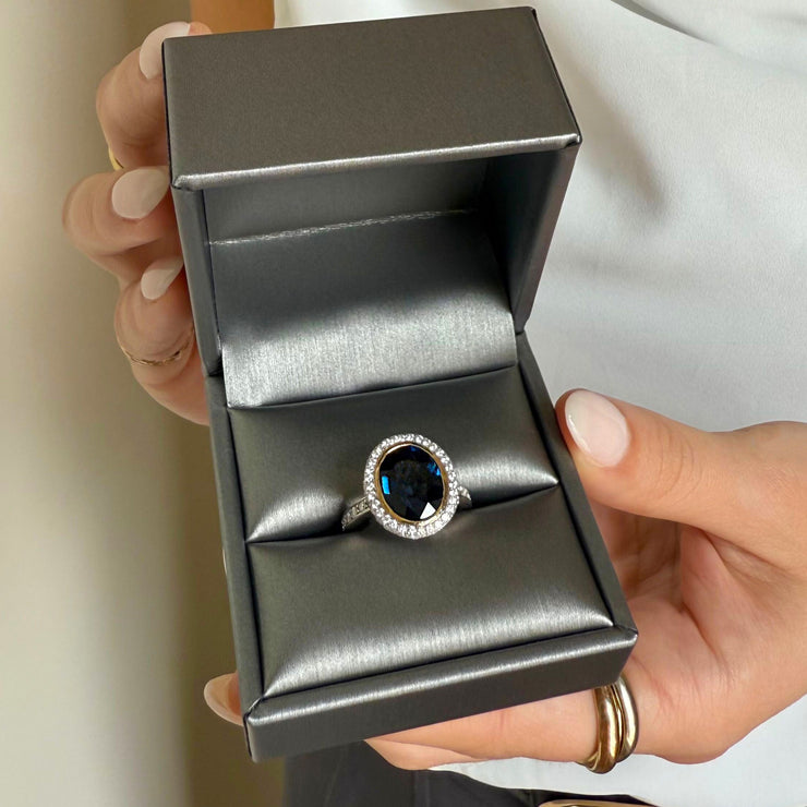 Fine jewelry ring with 6.60 carat blue sapphire, diamond halo, and platinum yellow gold setting
