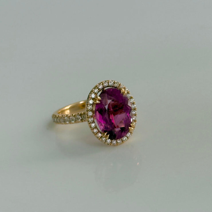 Exquisite 4.67 ct oval tourmaline ring in 18k rose gold, surrounded by a 0.48 ct diamond halo, highlighting deep, rich colors and refined design.