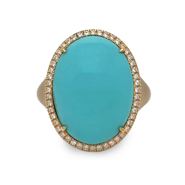 Close-up of vivid turquoise cabochon framed by round brilliant diamond halo