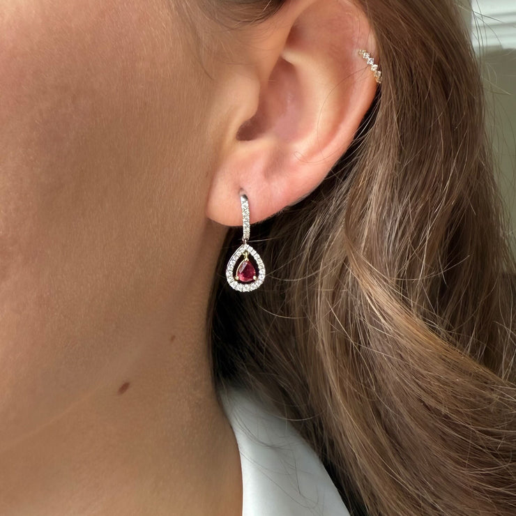 Model wearing pear shaped ruby diamond dangle earrings