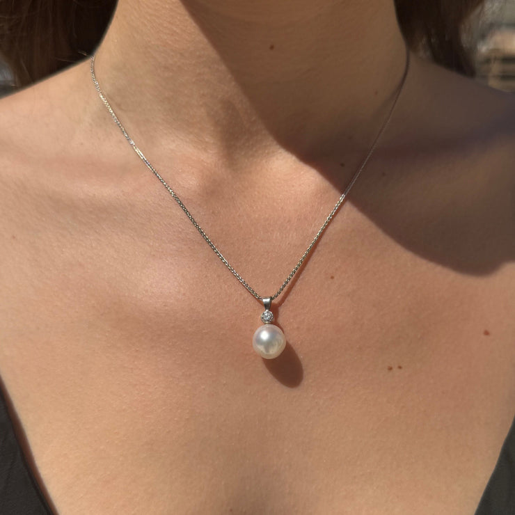 Pearl necklace with a bezel diamond on a woman's neck